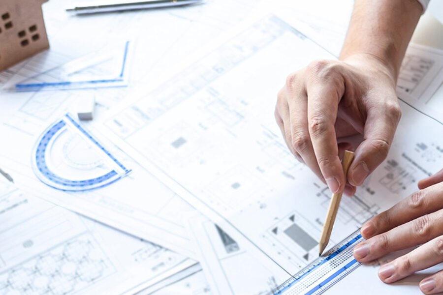 Team of engineering or architect meeting and discussing on blueprint and building model while checking information on sketching for architectural project.