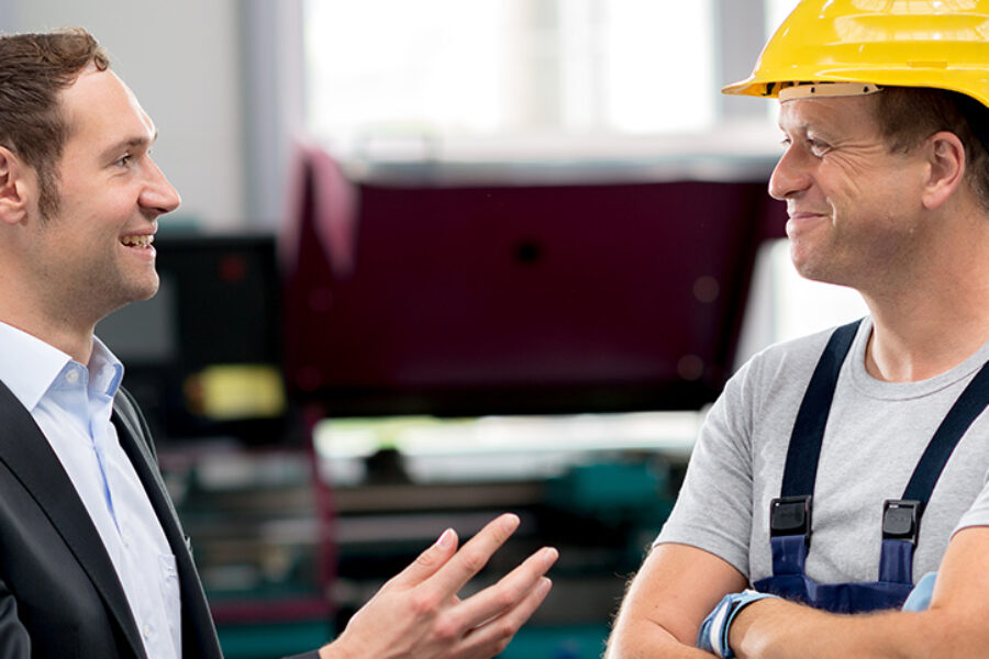 in the factory- young boss and worker in conversation